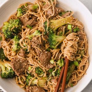 beef and broccoli ramen stir fry with chopsticks lifting up ramen noodles