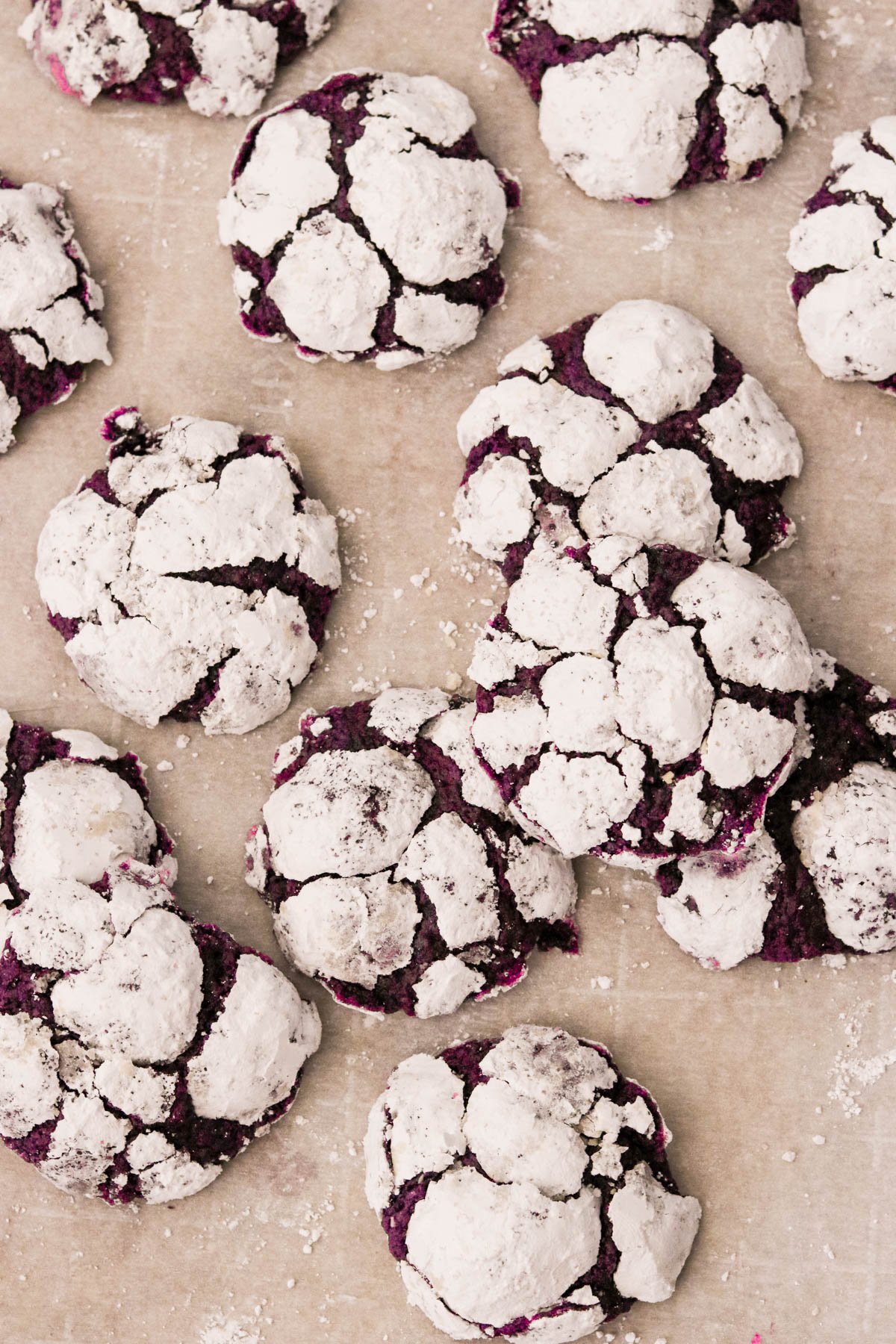 ube crinkle cookies on a parchment paper lined baking sheet