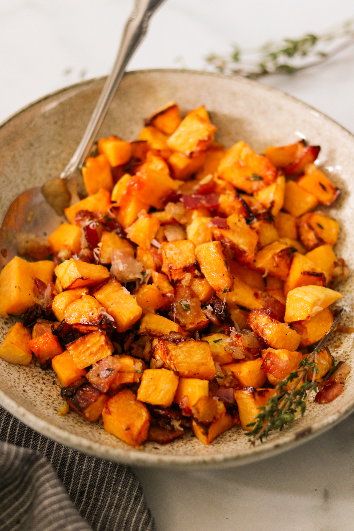 cooked butternut squash with bacon in a serving dish 