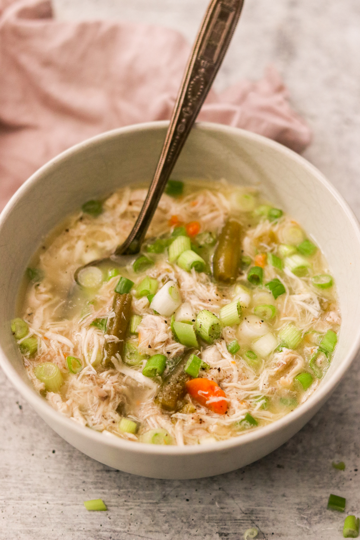 instant pot chicken soup in a white bowl with spoon resting on the side 