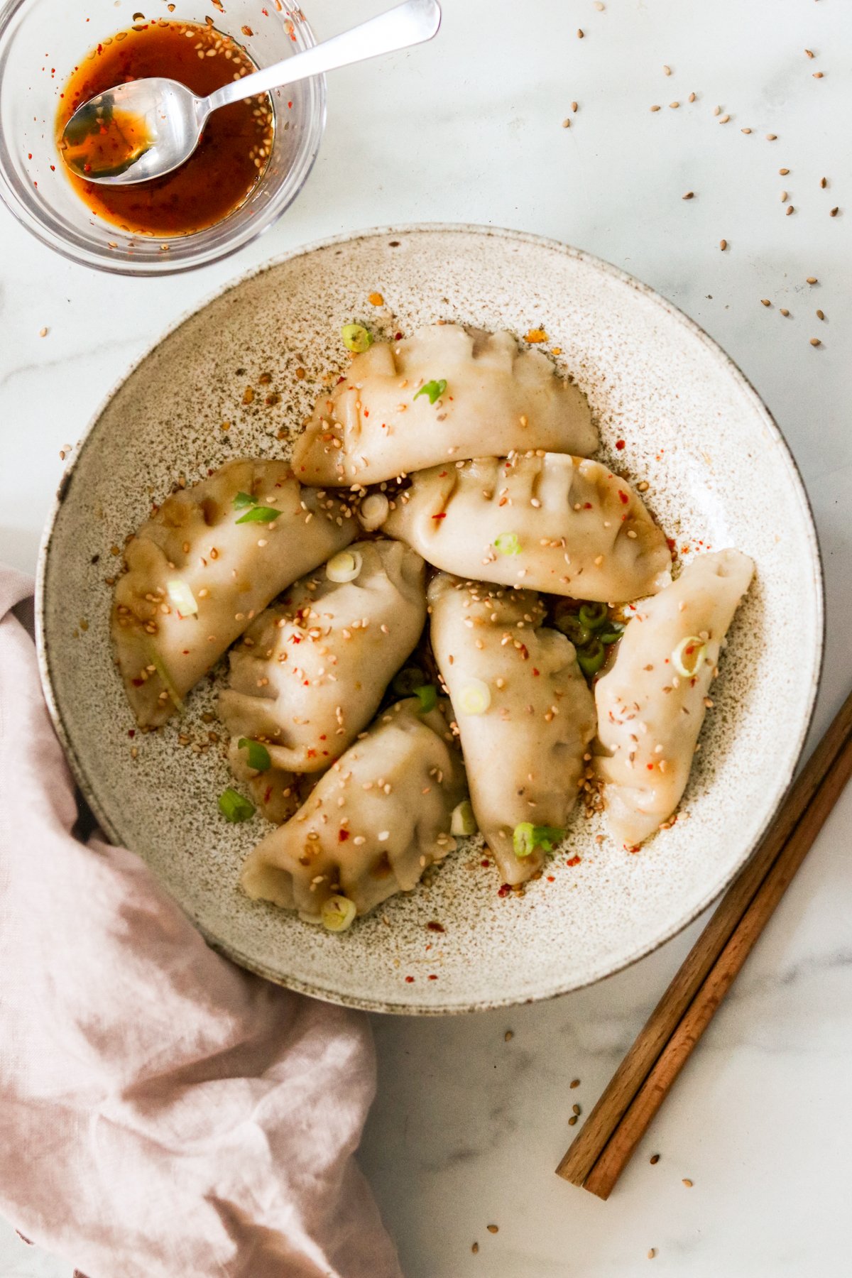 Korean dumplings, or mandu, on a plate drizzled with dipping sauce