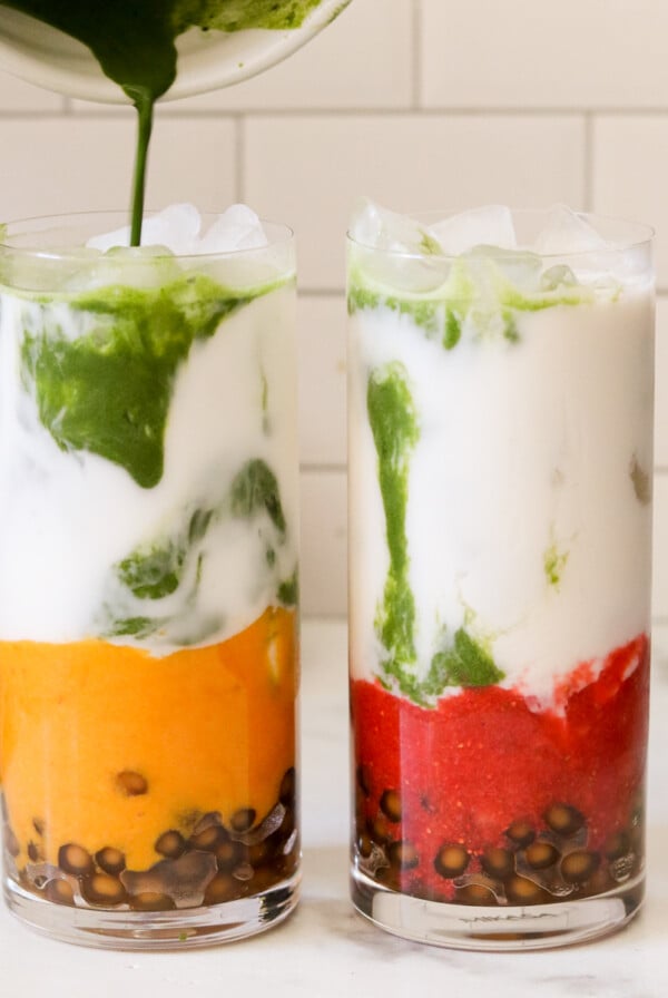 two glasses of matcha bubble tea with boba straws