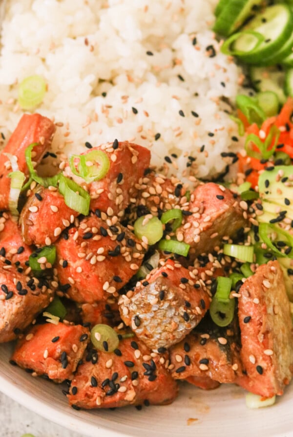 air fryer teriyaki salmon in a bowl of recipe topped with sesame seeds and green onions