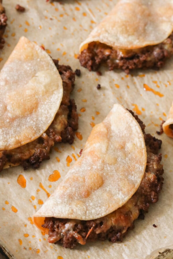 a sheet pan filled with crispy baked tacos