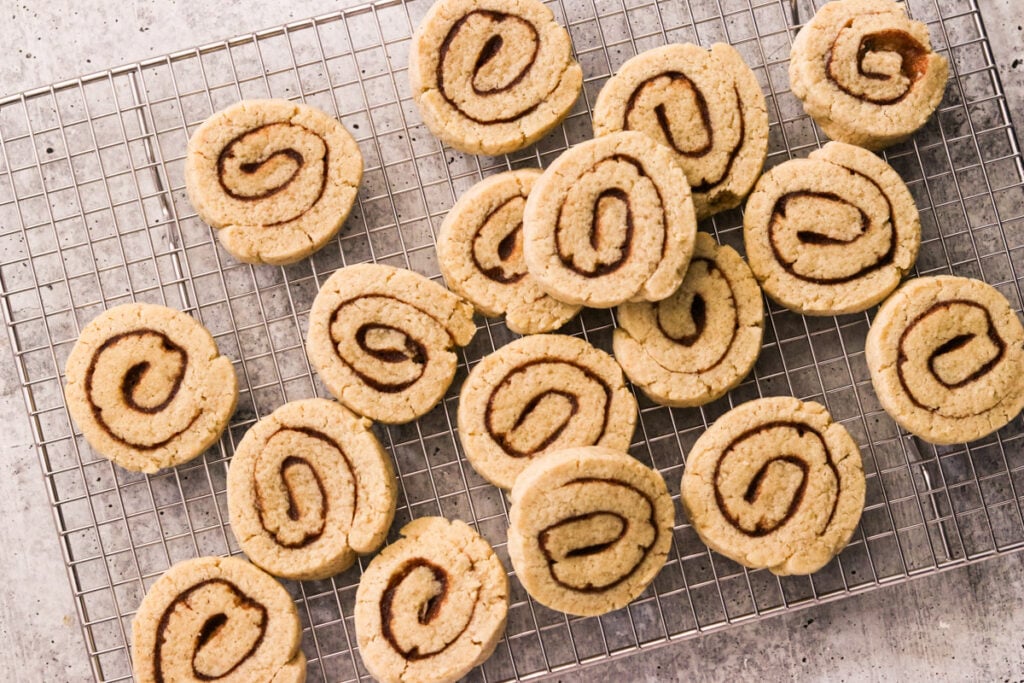 Baked cinnamon roll cookies cooling on a wire rack