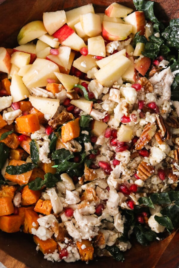 an overhead shot of a fall harvest salad in a wooden bowl