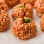 an up close photo of pumpkin shaped halloween rice krispie treats on a baking sheet