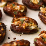 medjool date stuffed with brie, walnuts, honey, spices on a plate