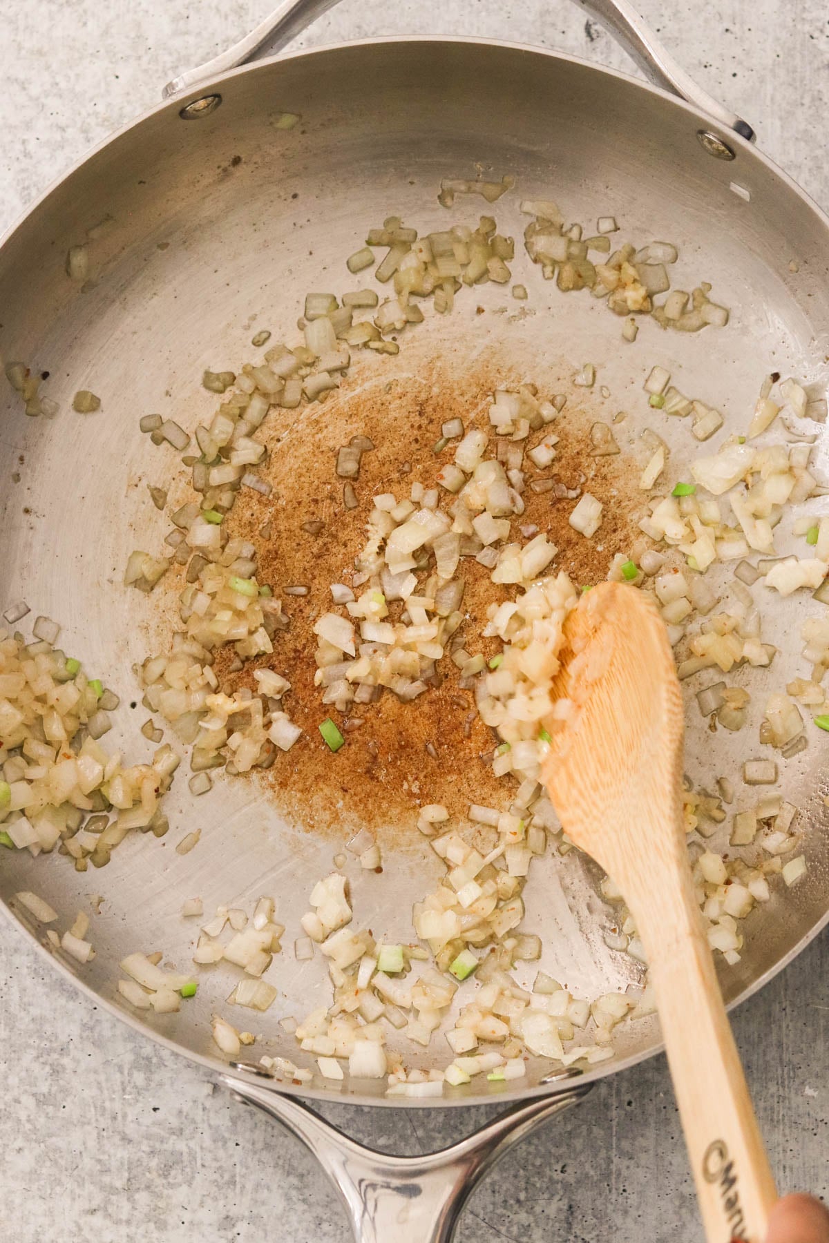 Chopped onion sauteeing in reserved bacon fat in a pan.