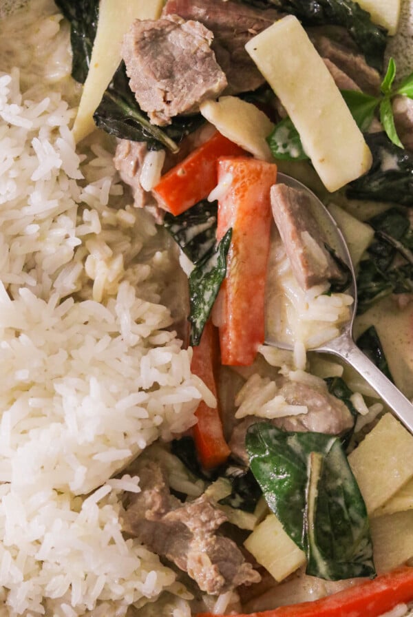 a bowl of Thai green curry with beef and veggies over a bed of rice