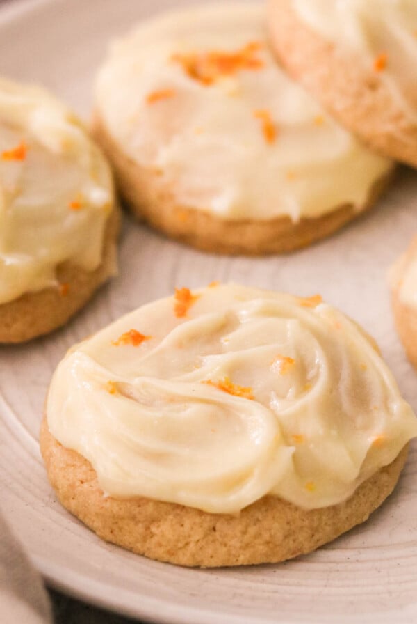 a plate of orange cookies topped with frosting