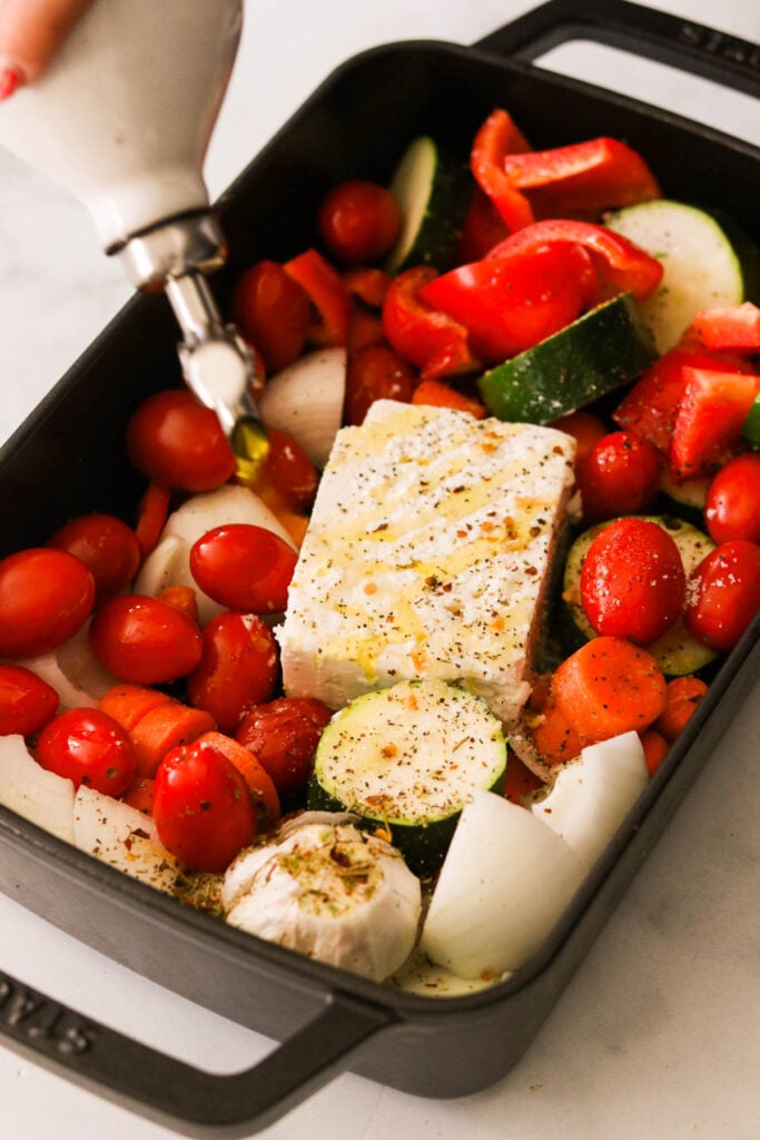 drizzling olive oil over veggies and feta cheese