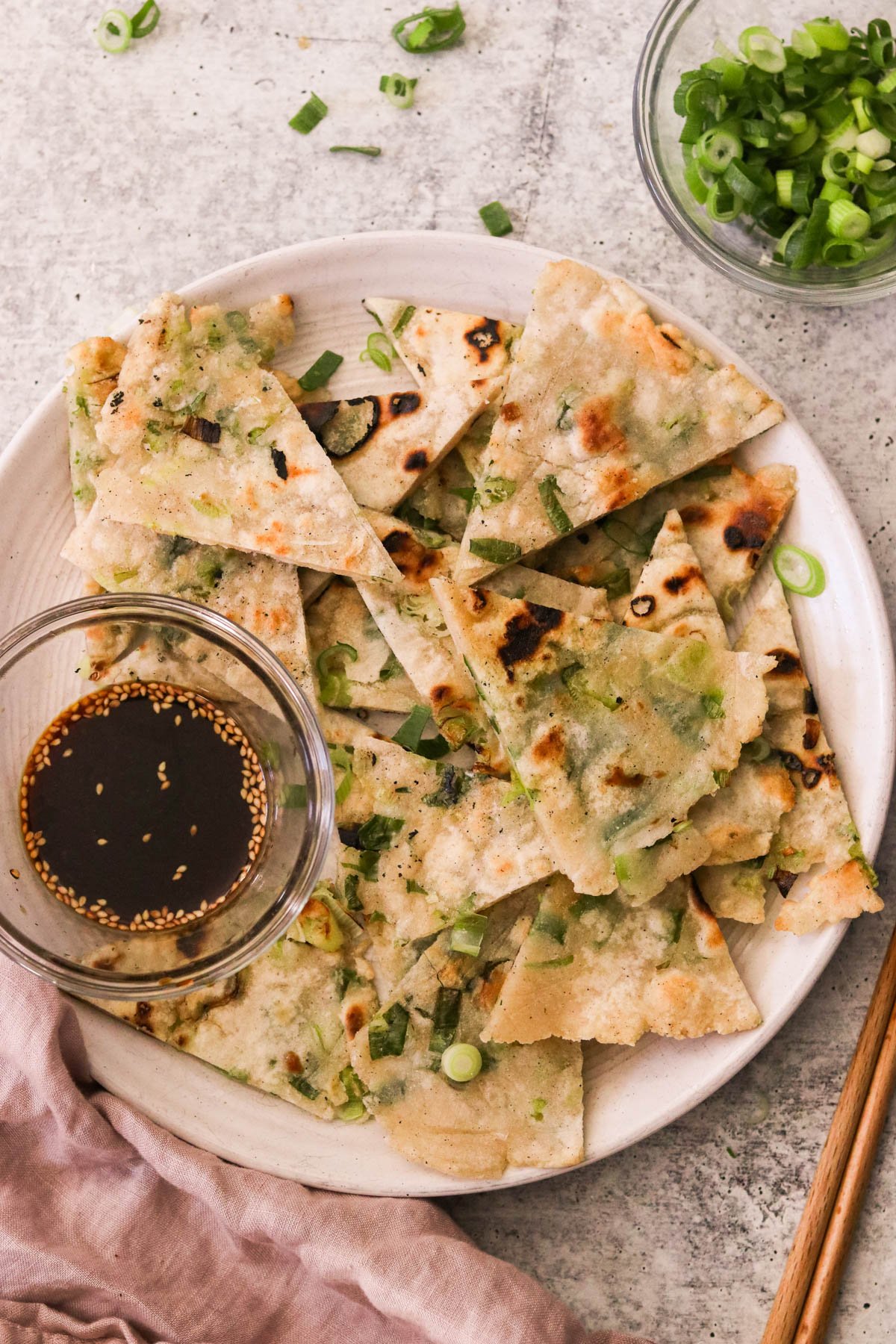 gluten free scallion pancakes on a white plate with dipping sauce 