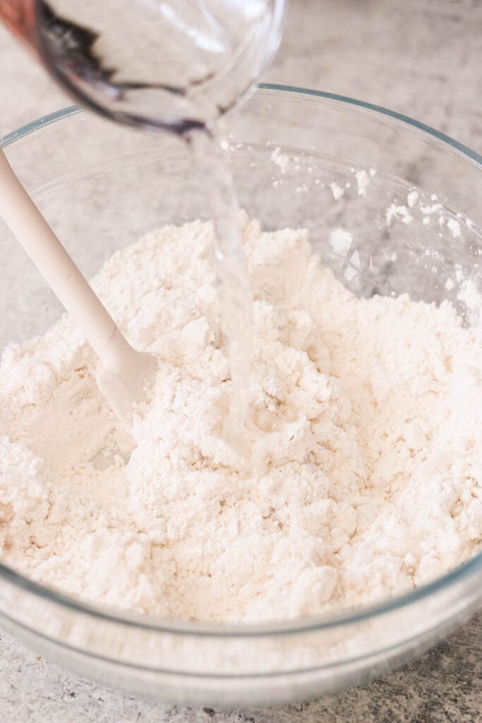 adding boiling water into a bowl of dry ingredients 