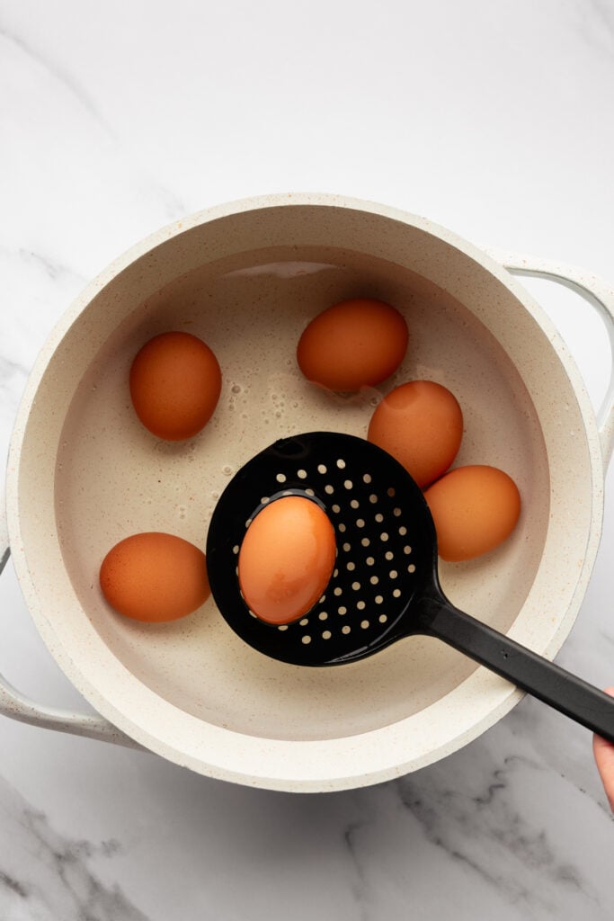 brown eggs in a pot of water