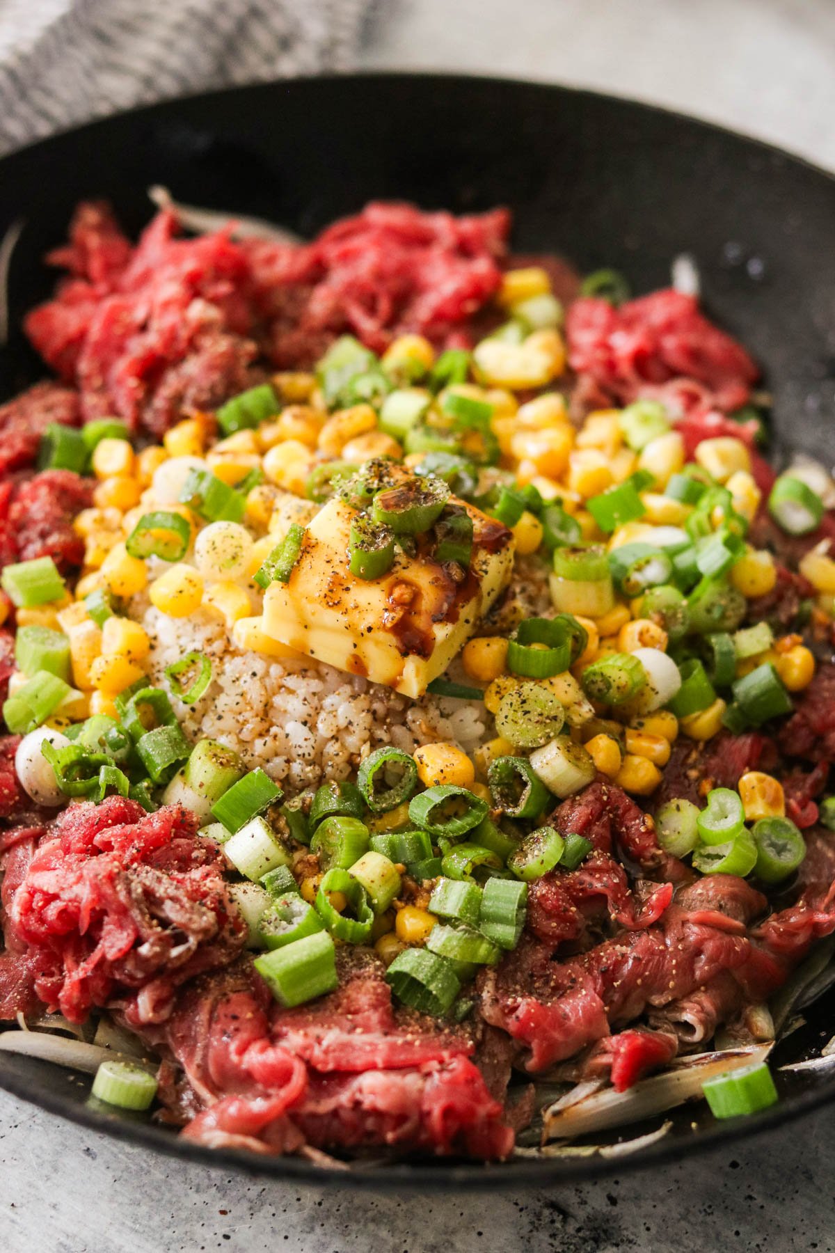 beef pepper rice cooking in a cast iron pan 