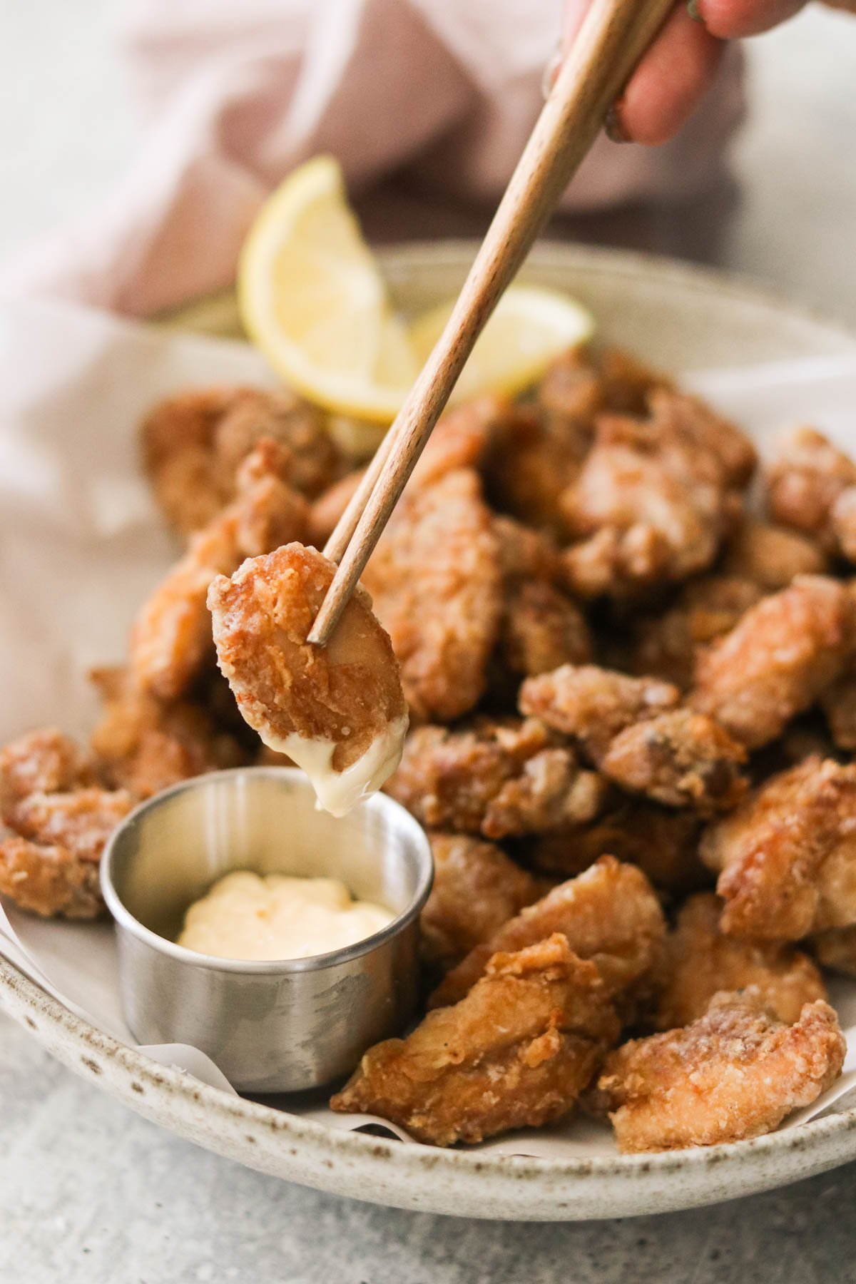 dipping air fryer karaage into a bowl of mayo 