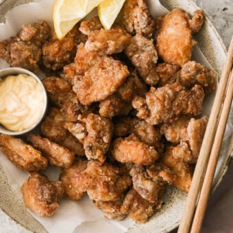 air fryer karaage (fried chicken thighs) on a plate with mayo and lemon wedges