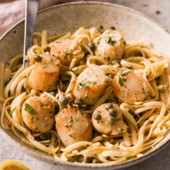 scallop piccata pasta served in a bowl with a fork