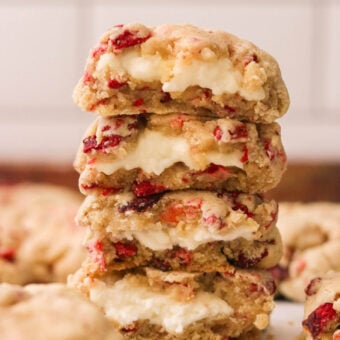 four strawberry cheesecake cookies stacked on top of each other