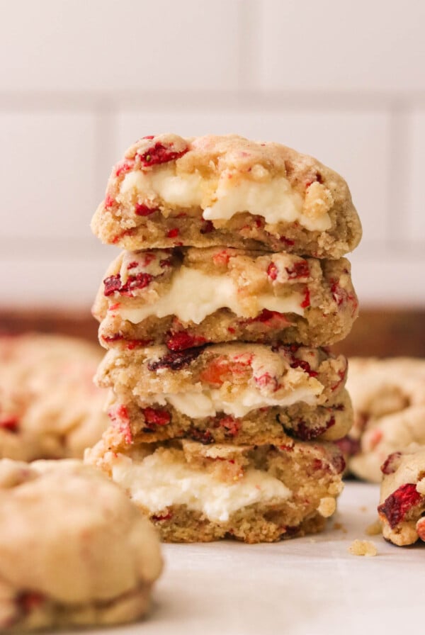 four strawberry cheesecake cookies stacked on top of each other