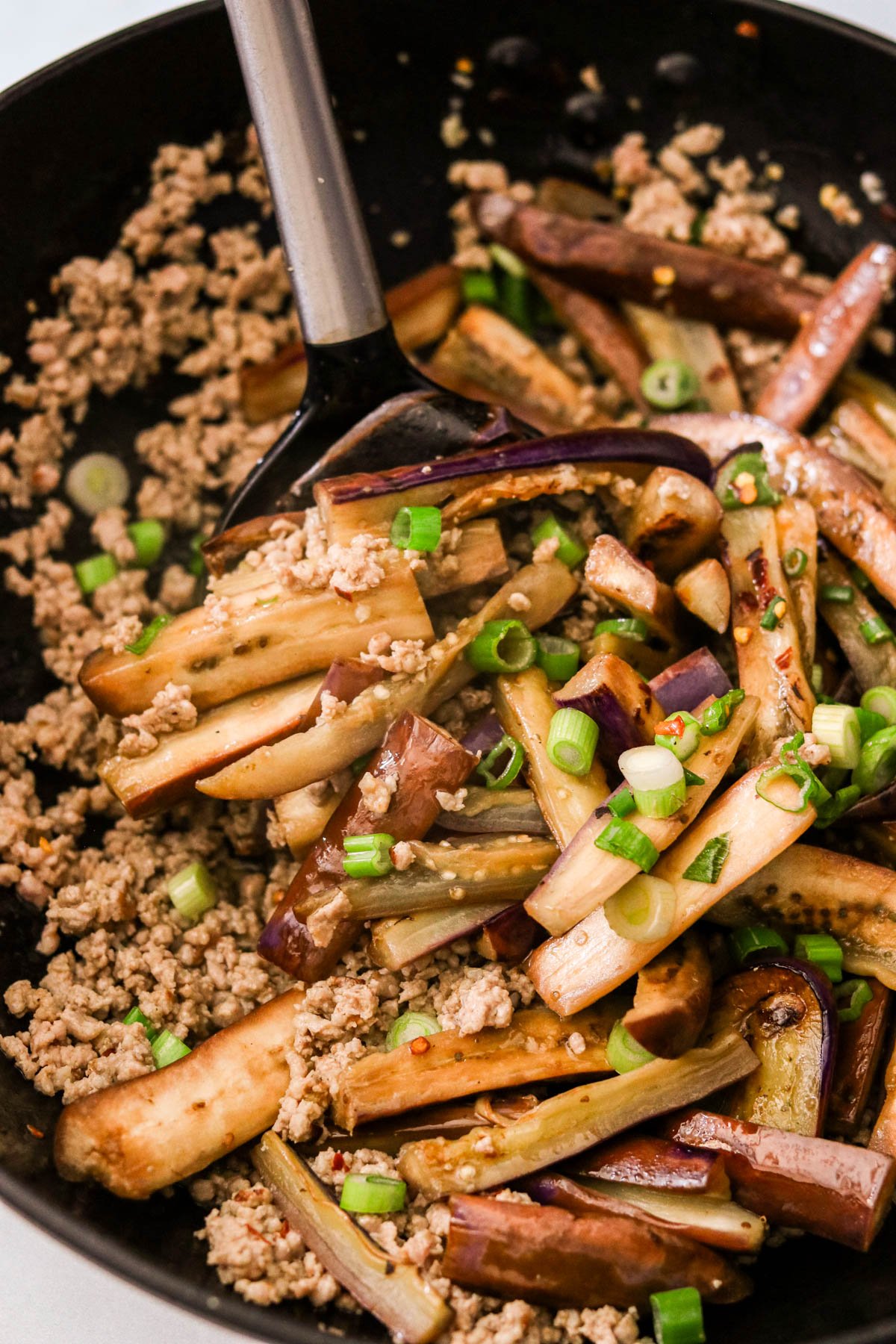 eggplant mixed with pork in a skillet to make a stir fry