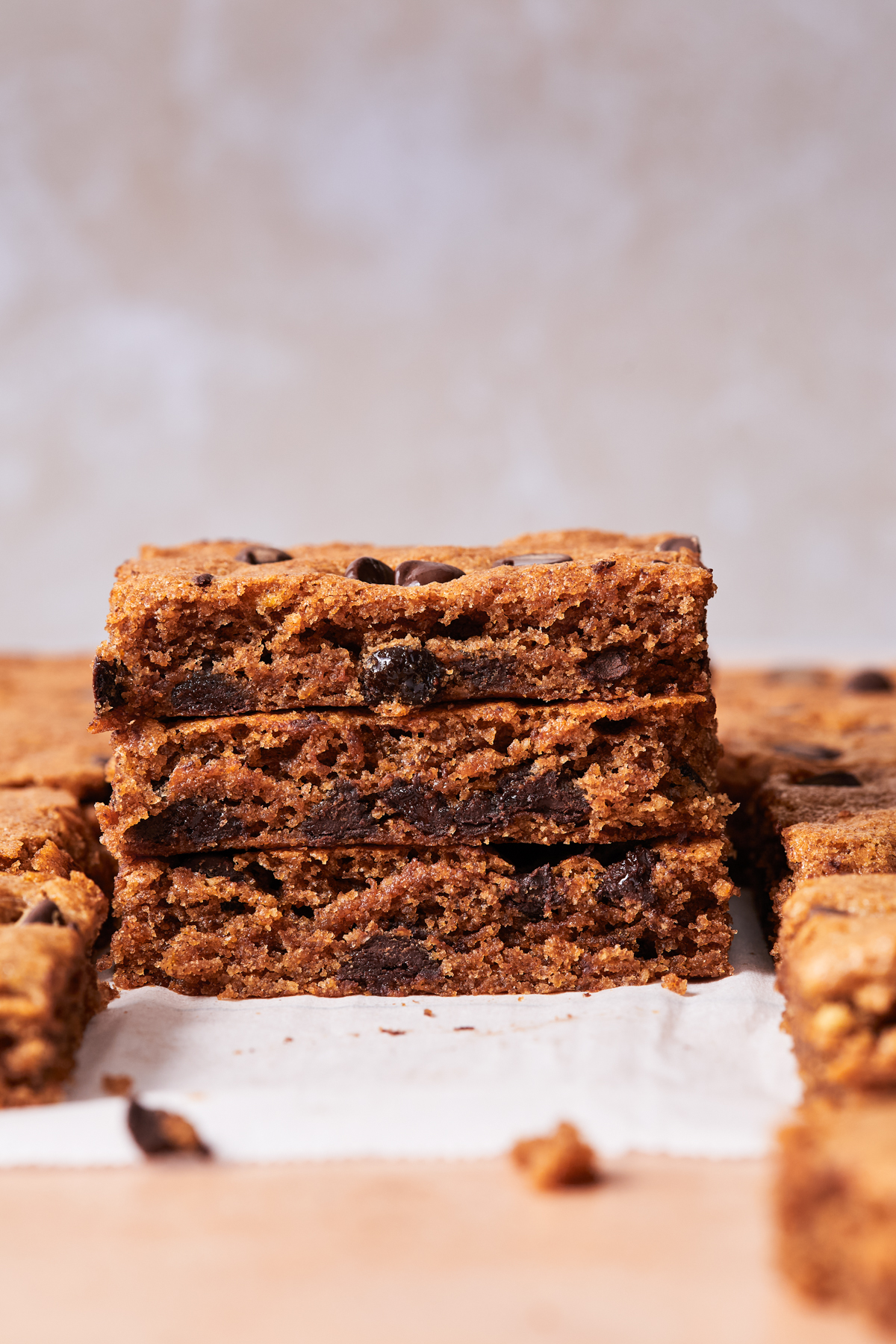 Stack of chewy gluten-free chocolate chip blondies on a cooling rack