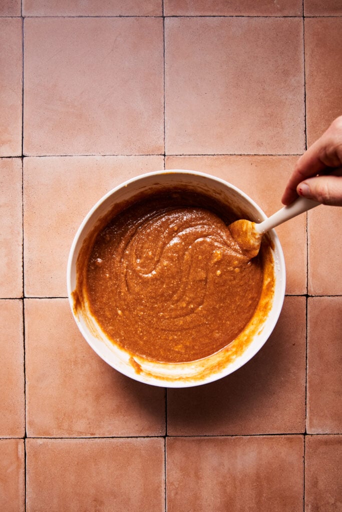 Whisking wet ingredients including almond butter and maple syrup