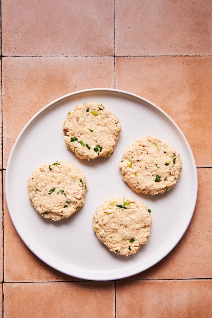 Formed tuna patties on a cutting board before cooking