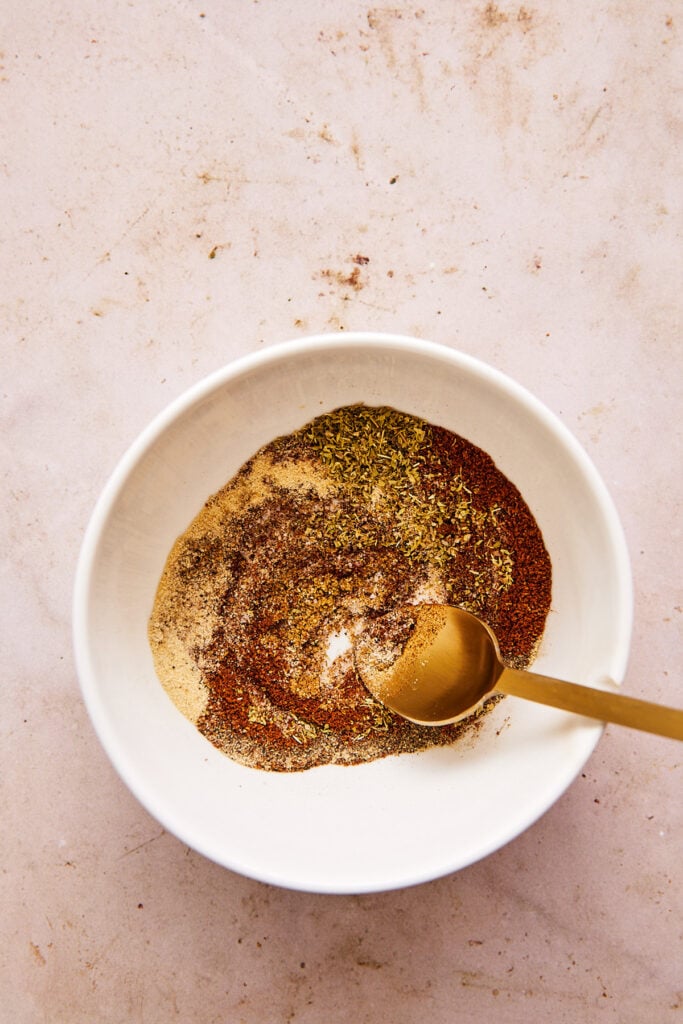 mixing the spice mixture in a white bowl 