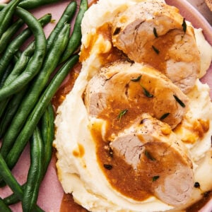instant pot pork tenderloin medallions on a plate with mashed potatoes and green beans