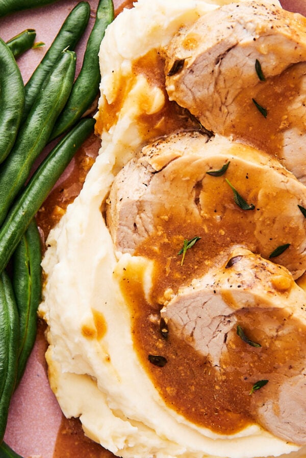 instant pot pork tenderloin medallions on a plate with mashed potatoes and green beans