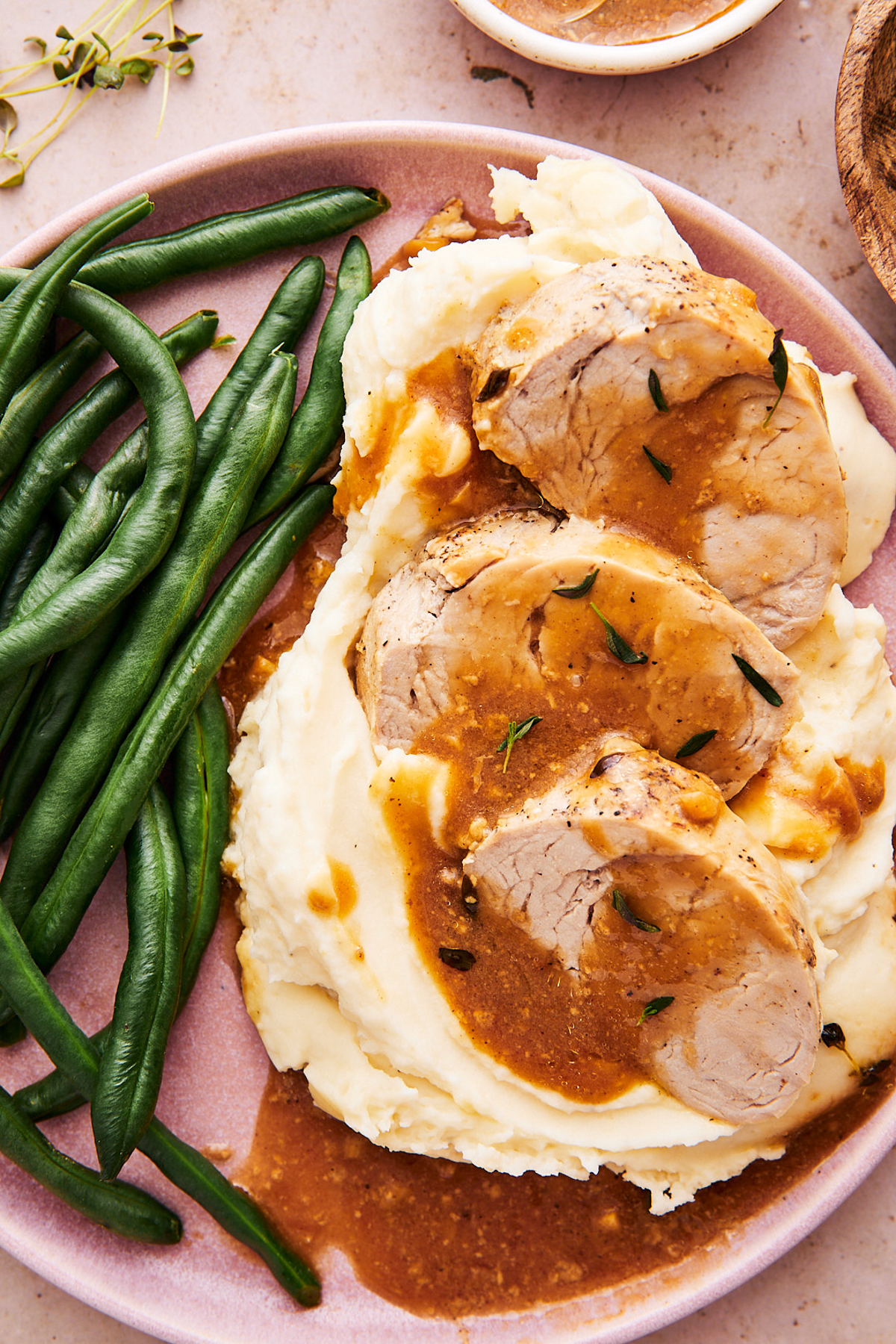 instant pot pork tenderloin medallions on a plate with mashed potatoes and green beans