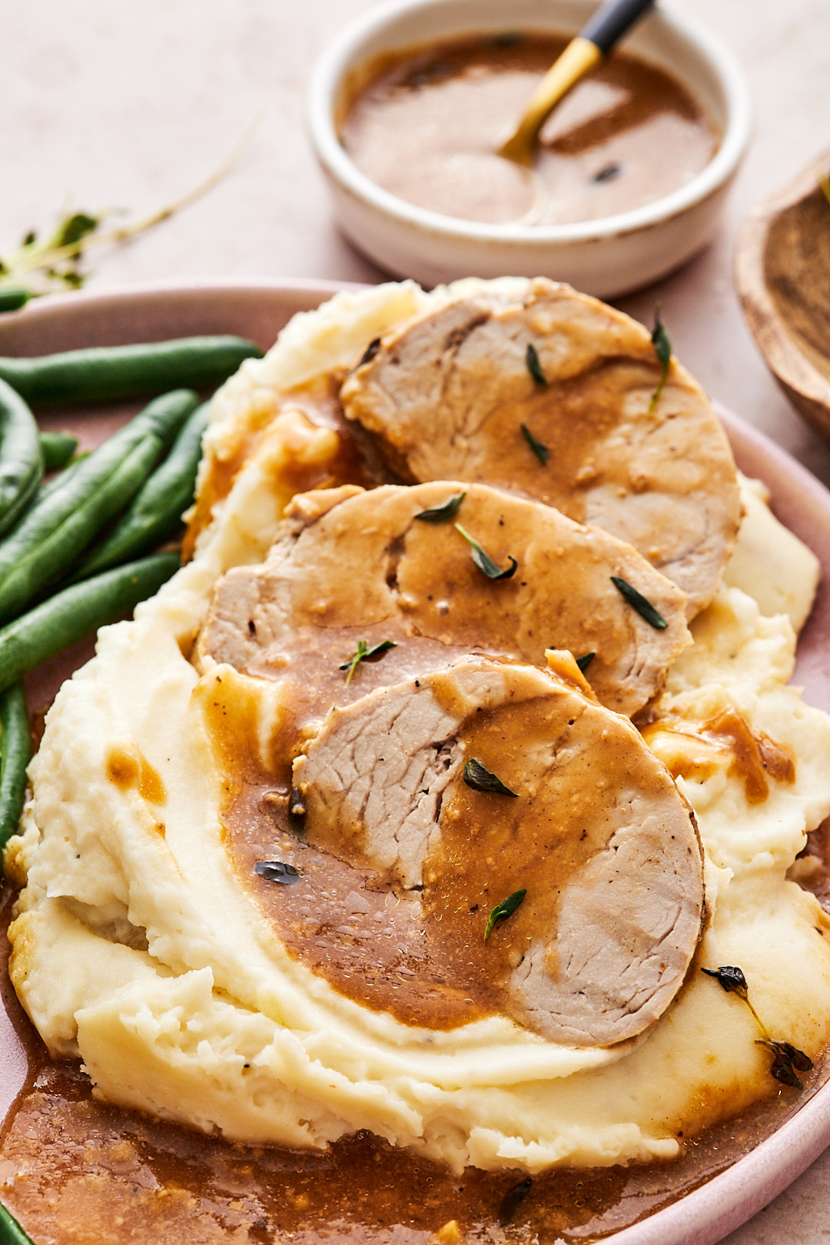 pork medallions on top of mashed potatoes drizzled with gravy