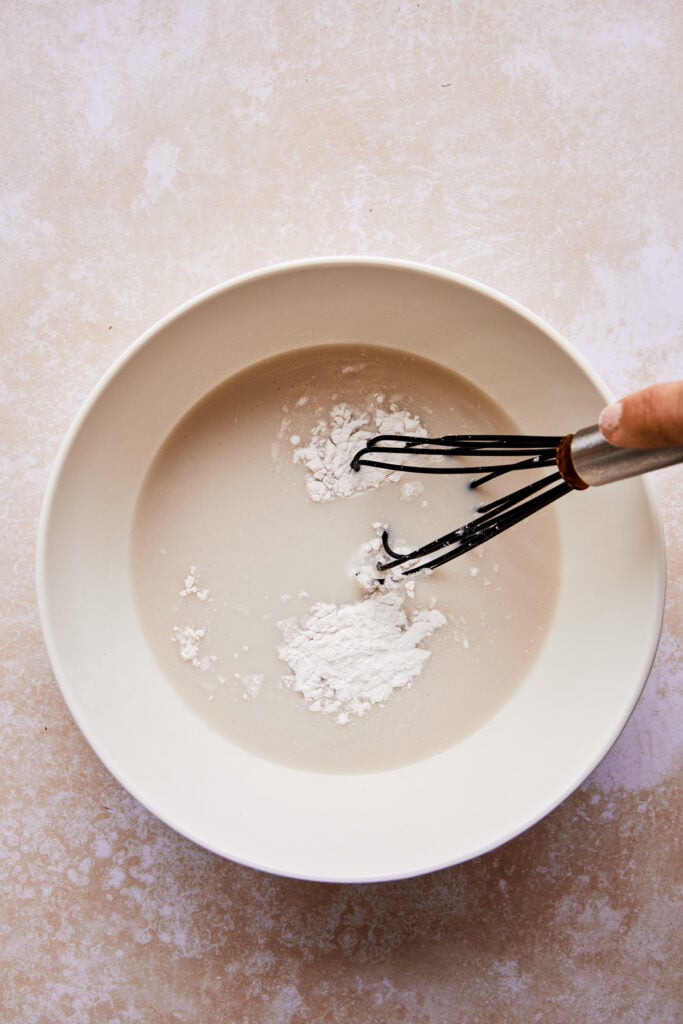 whisking the milk and arrowroot in a bowl