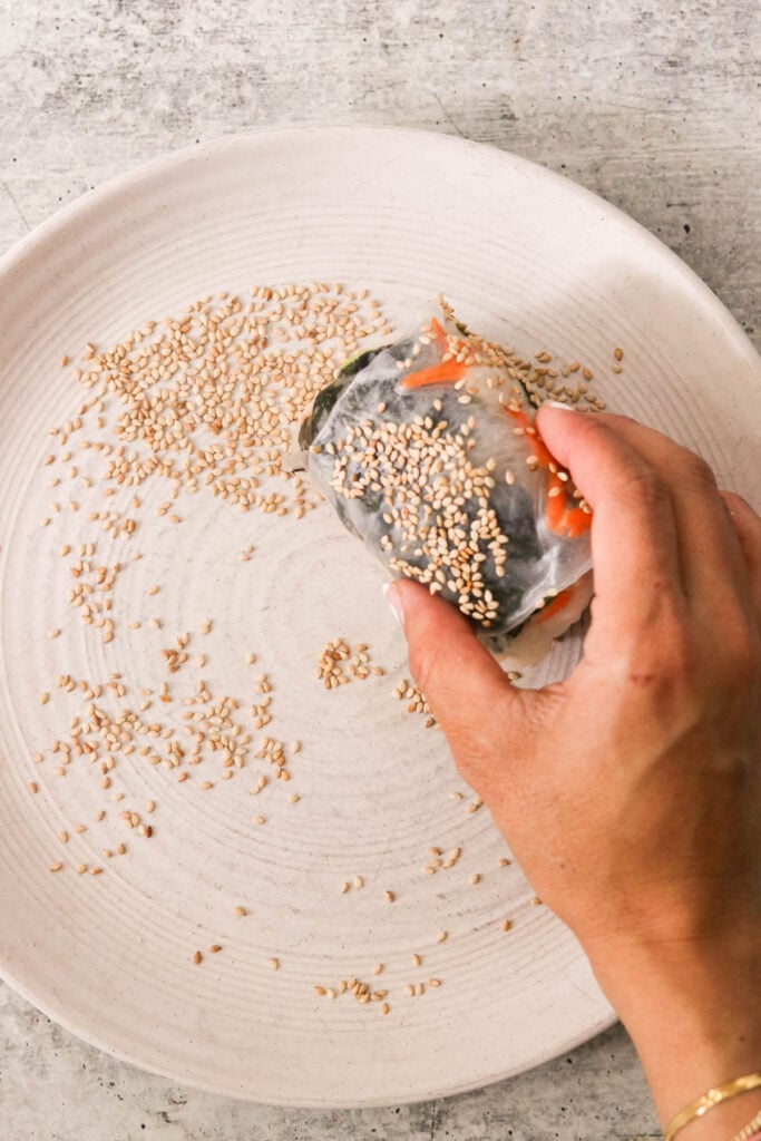 rice paper roll coated with sesame seeds on a plate