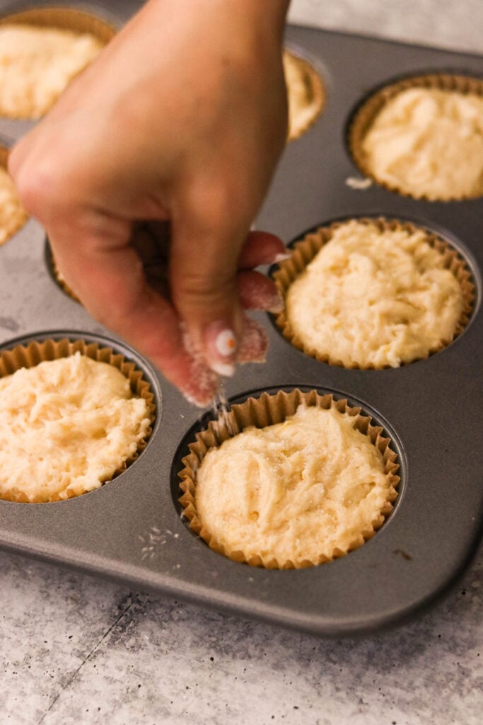 Muffin batter divided into a parchment-lined muffin tin

