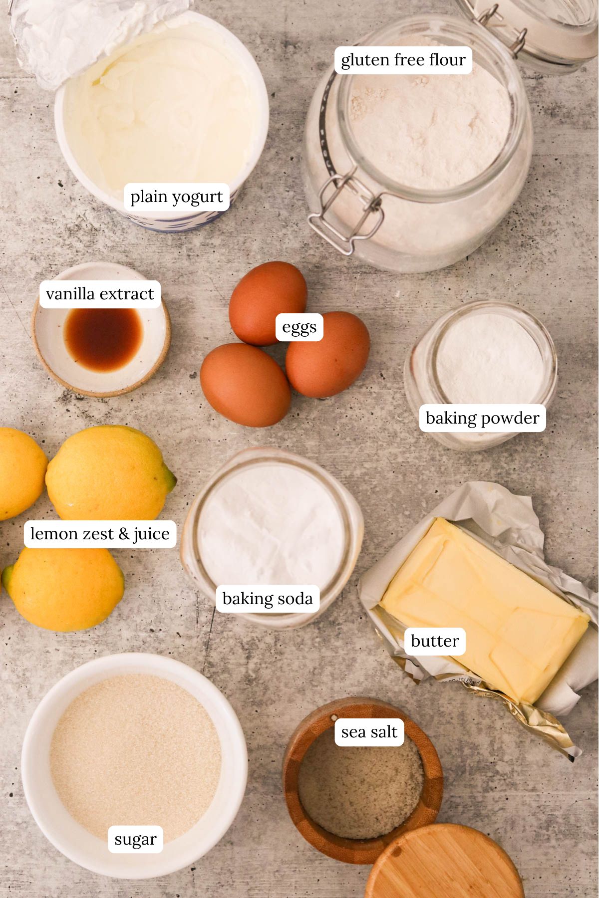 Flat lay of ingredients for lemon curd muffins including flour, eggs, lemons, and butter