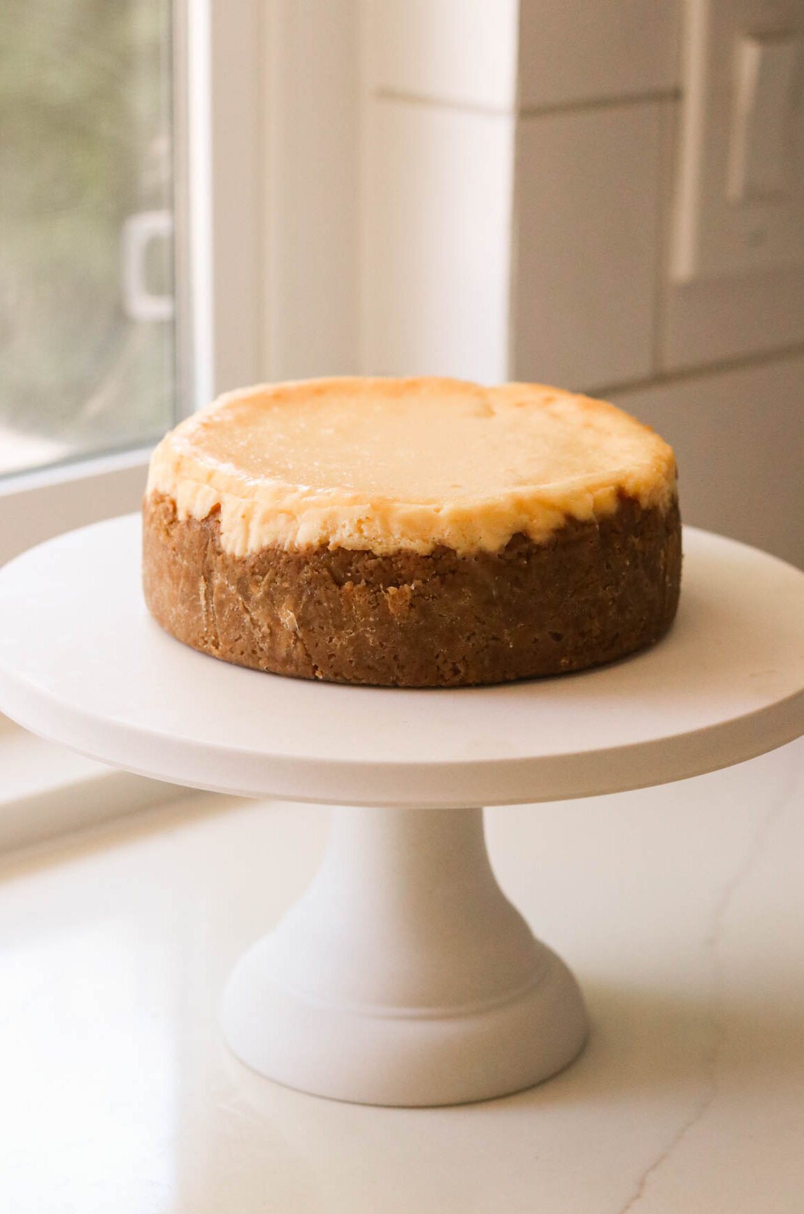 a full cheesecake on a white cake stand