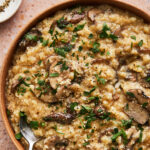 instant pot cauliflower risotto in a large serving dish topped with fresh basil