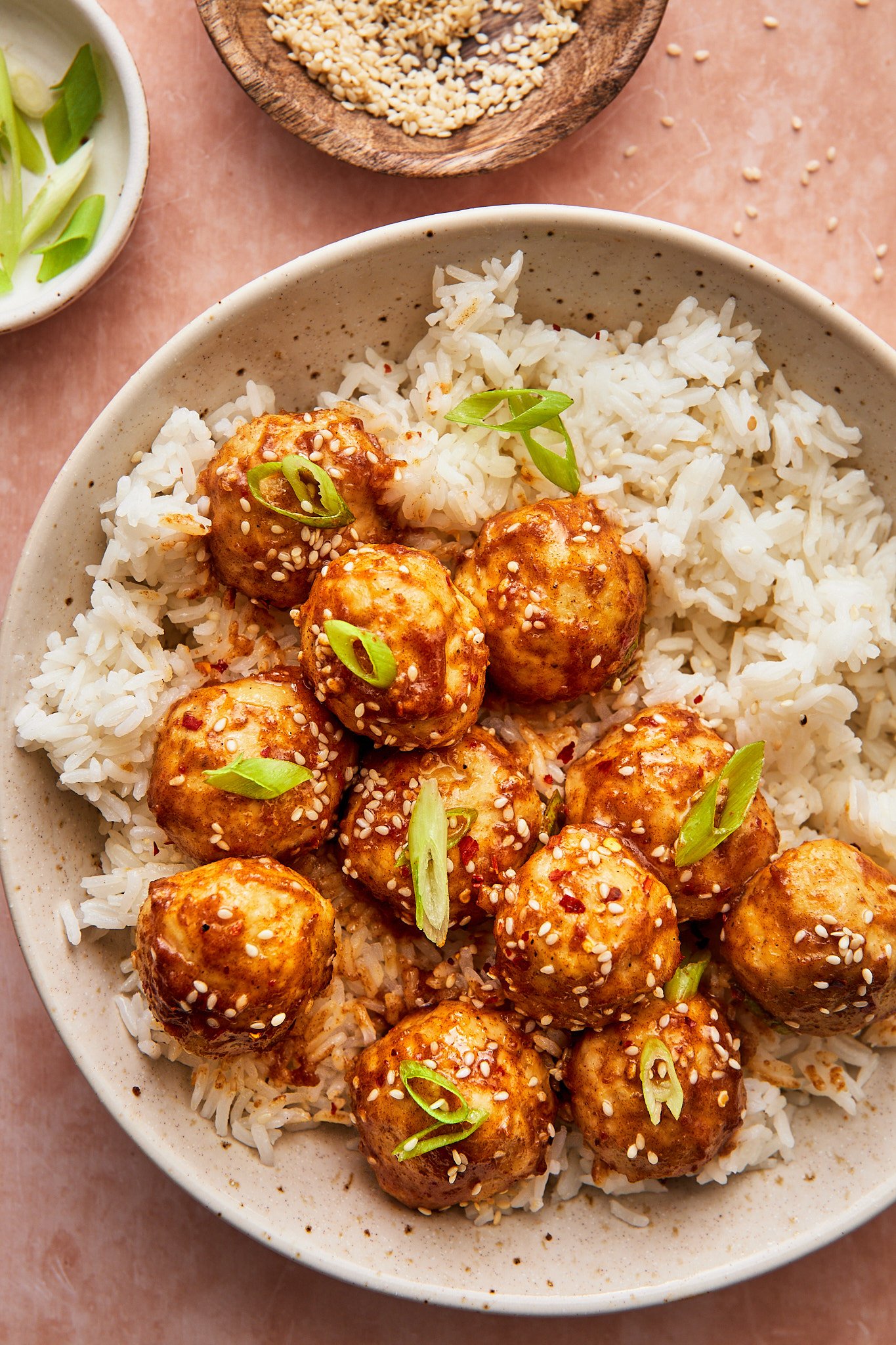 sticky asian chicken meatballs served on a plate with a side of fluffy white rice 