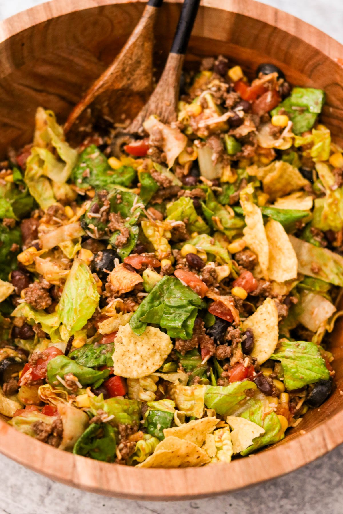 Styled final shot of Crispy Taco Salad with Tangy Catalina Dressing in a rustic wooden bowl, ready to serve
