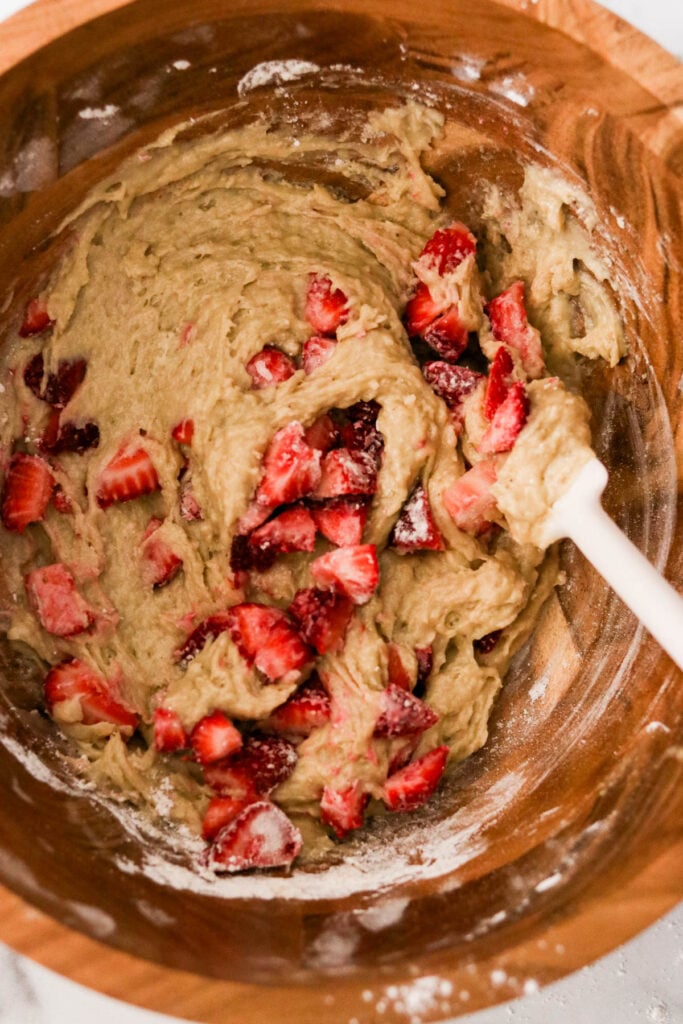 folding chopped strawberries into the strawberry banana cake batter. 