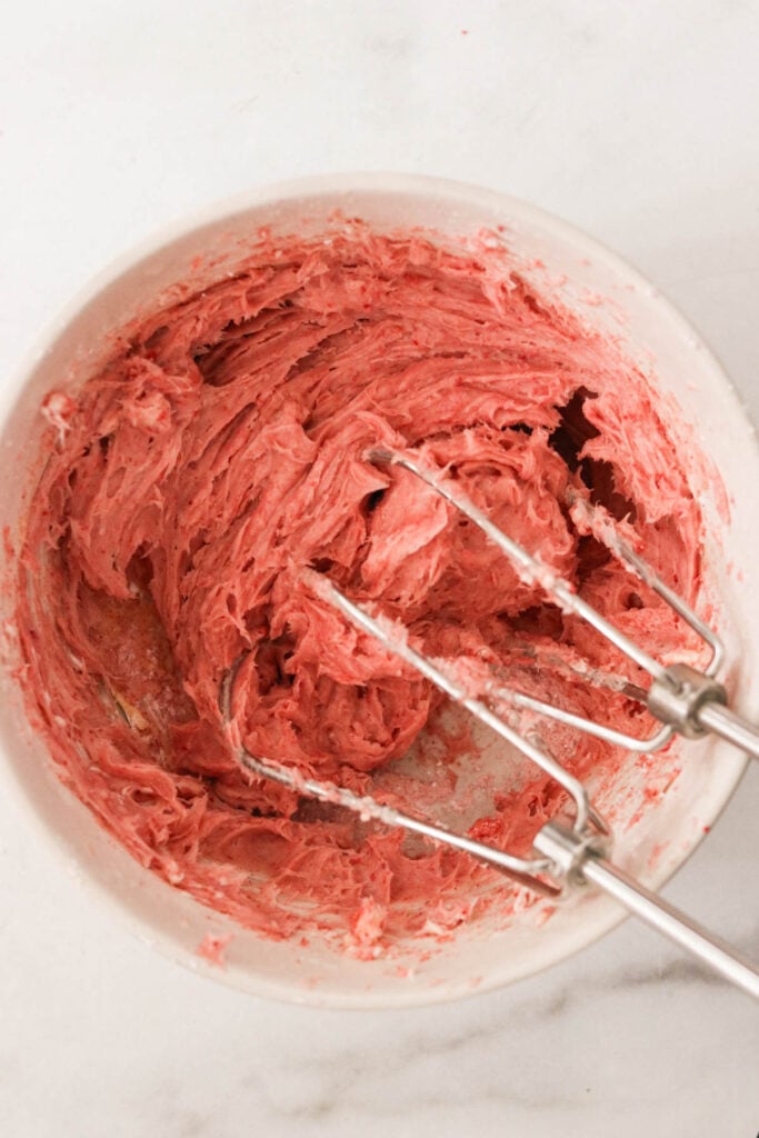 hand mixers making strawberry cream cheese frosting. 