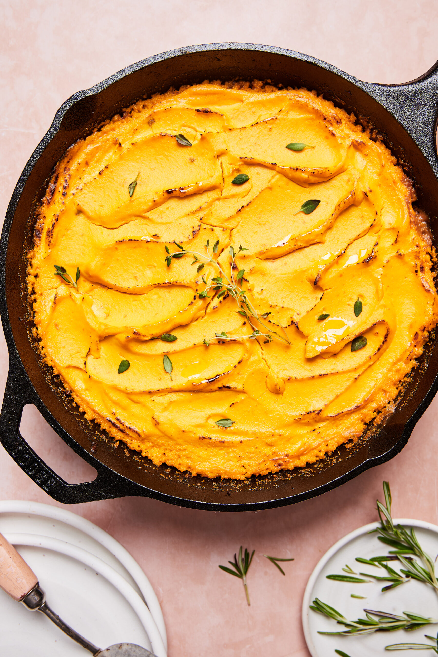 Low-carb shepherd’s pie fresh from the oven with golden topping garnished with fresh herbs.