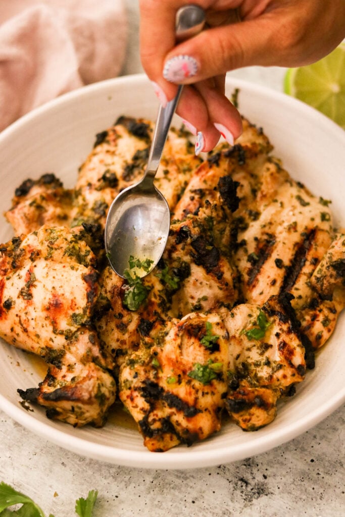 Grilled cilantro lime chicken resting in a white bowl 
