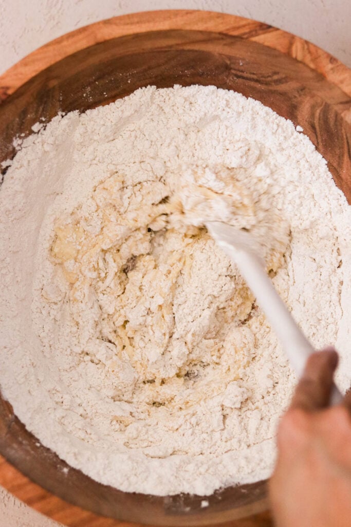 Dry ingredients like flour and baking powder being mixed into waffle batter 