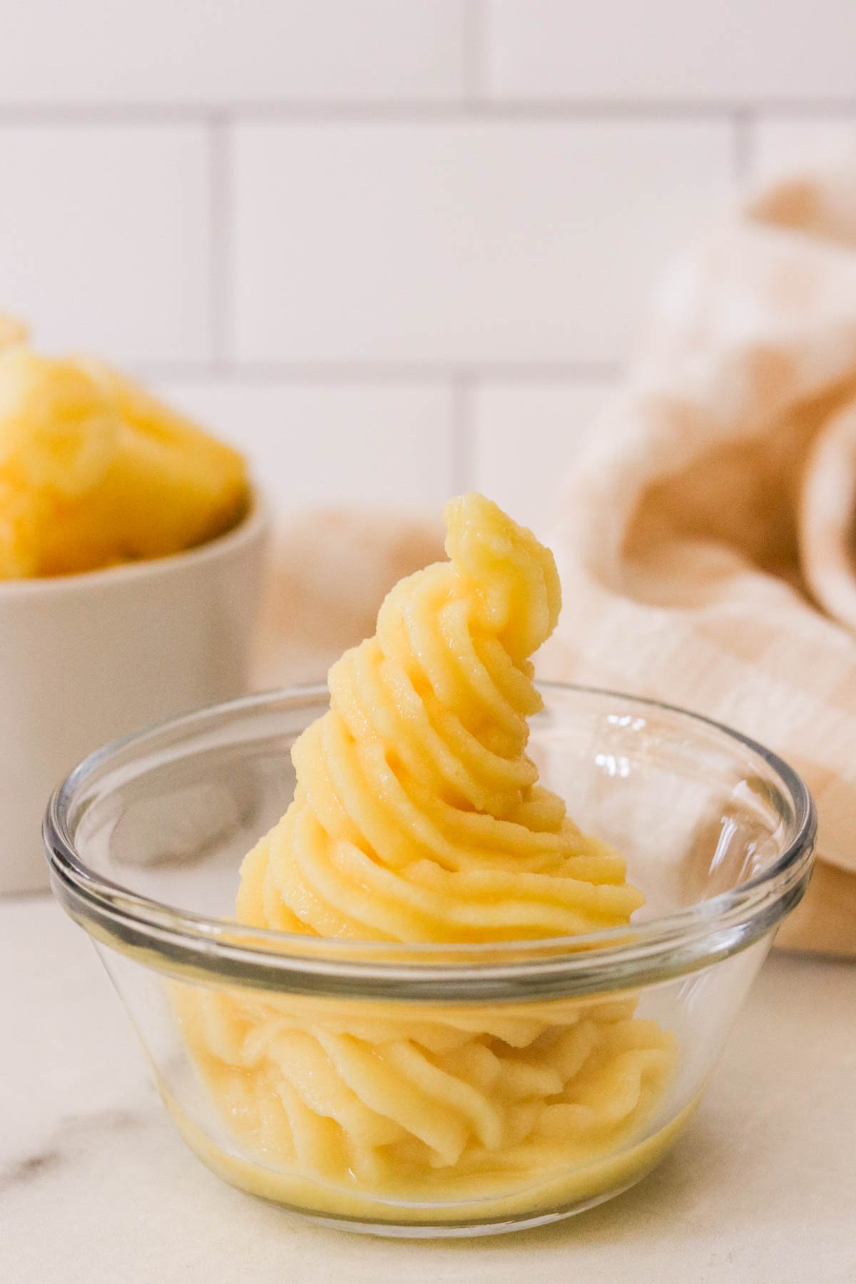 Swirled pineapple Dole Whip in a bowl, vegan soft serve with creamy texture