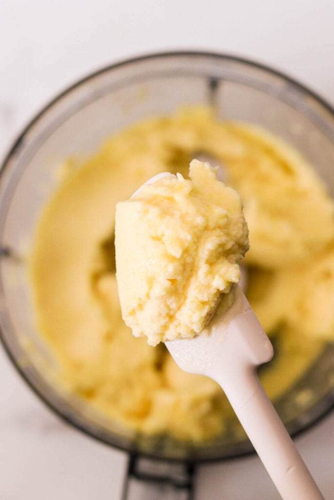 Blended pineapple Dole Whip mixture in a food processor, creamy soft-serve texture