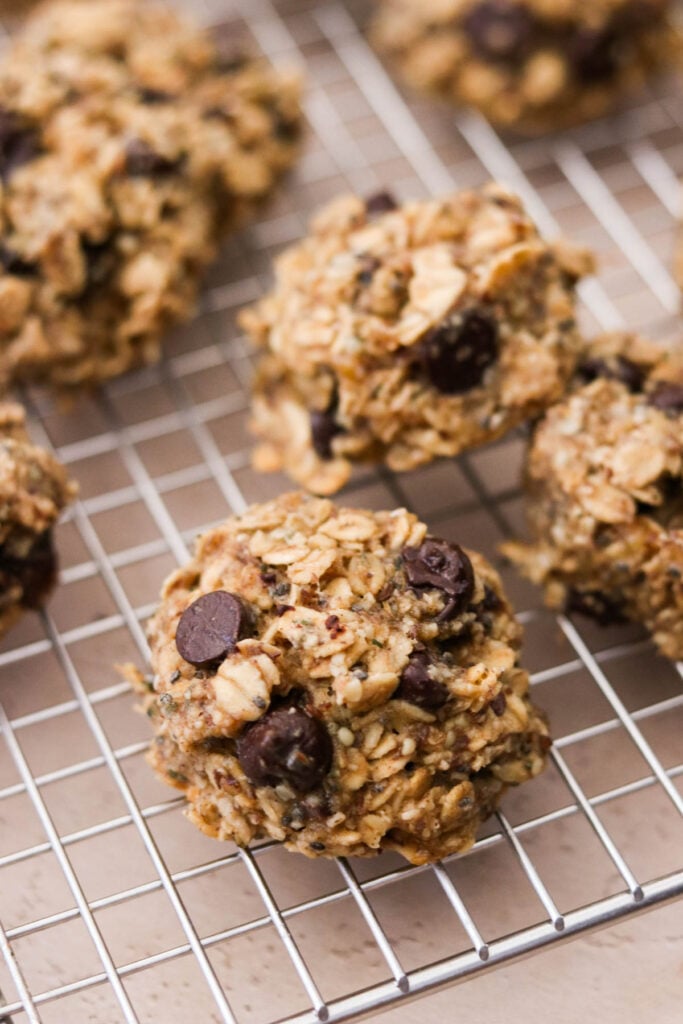 Baked breakfast oatmeal cookies cooling on a wire rack with puffed centers and golden edges.
